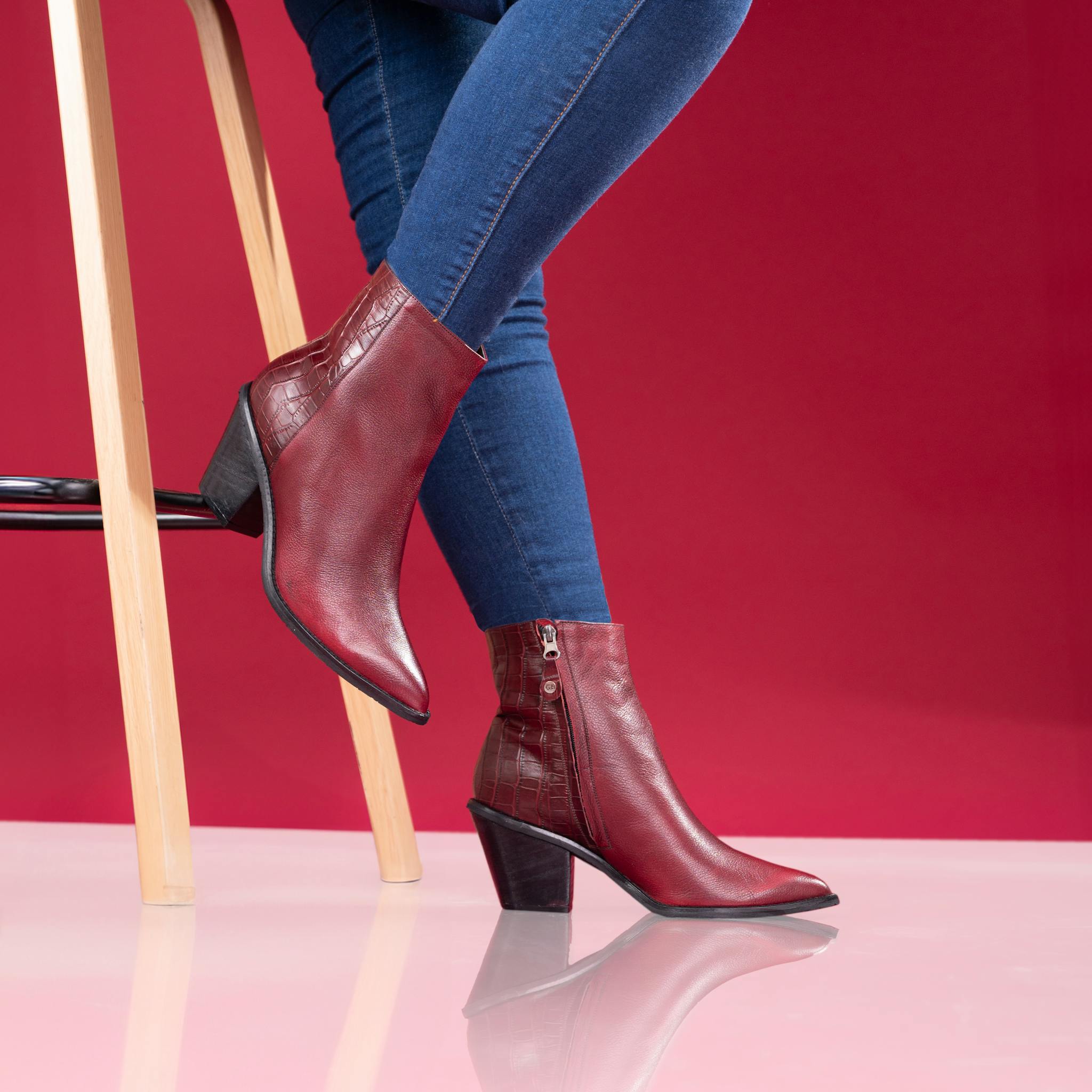 Fashion-forward red leather boots paired with blue denim for a chic look.