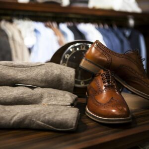 Stylish leather shoes displayed with gray clothing in a chic boutique setting.